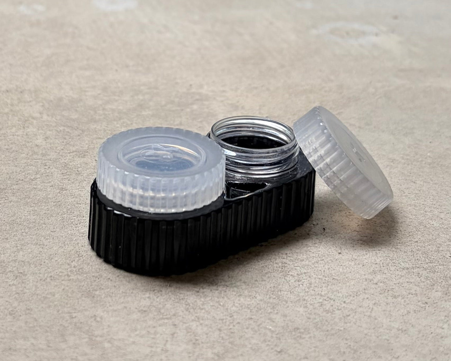 A black contact lens case with white caps